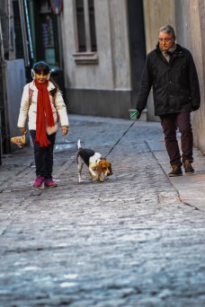 A grandfather and his granddaughter go for an afternoon stroll in the old town of Madrid with their loyal companion.